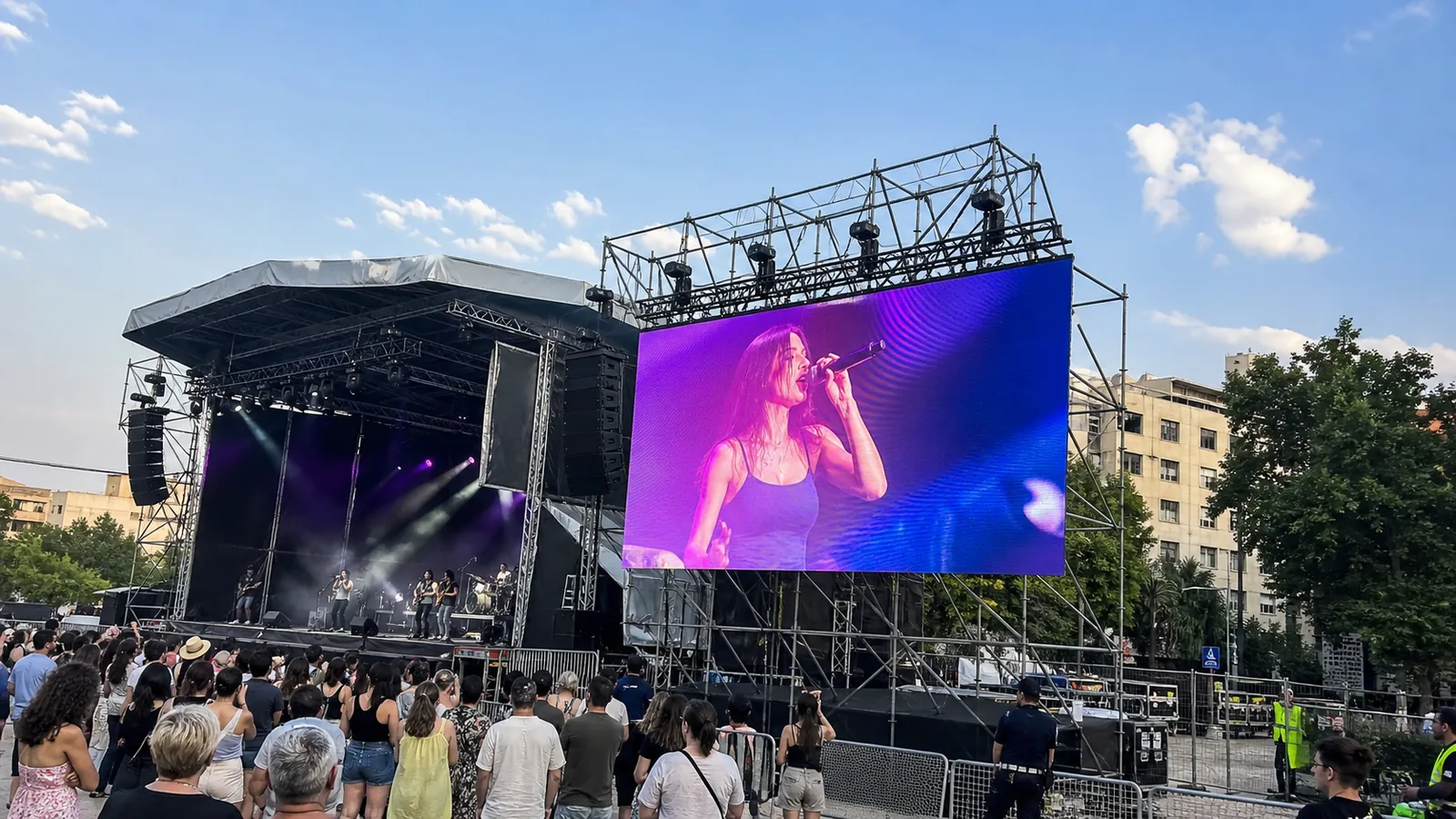Pantalla LED exterior junto al escenario de un festival durante el día